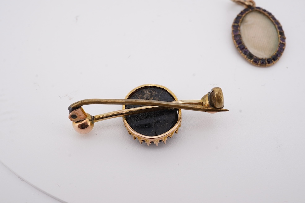 Three assorted Victorian brooches including a 9ct and garnet cluster by Murrle Bennett & Co, 27mm, a micro mosaic bar brooch and a yellow metal and split pearl mourning brooch, together with a gem set oval pendant. Condi
